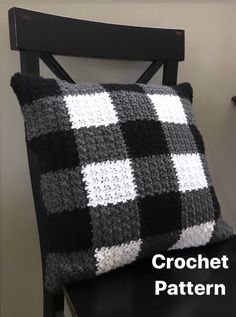 a black and white pillow sitting on top of a chair