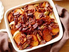 a casserole dish filled with apples and pecans