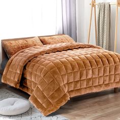 a bed with a brown comforter and pillows