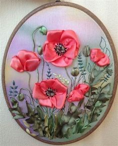 an embroidery project with pink flowers and green leaves