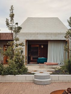 an outdoor patio with a couch, table and fire pit in the middle of it