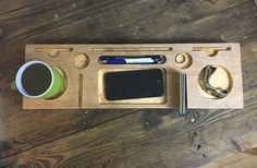 a wooden tray with various items on it and a cup of coffee next to it