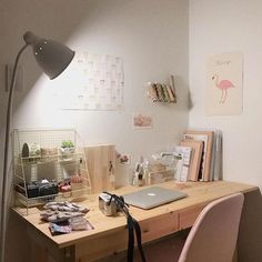 a desk with a laptop computer on top of it next to a chair and lamp