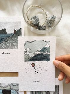 three cards with pictures of people in the water and rocks next to them on a table