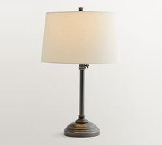 a table lamp with a white shade on it's base and a light bulb