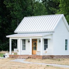 a small white house with a metal roof