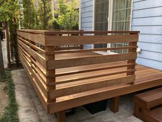 a wooden bench sitting on the side of a house