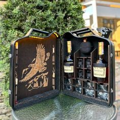 an open case with two bottles in it sitting on a table next to a tree