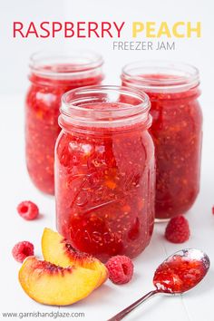 raspberry peach freeze jam in mason jars with spoons and fresh fruit on the side