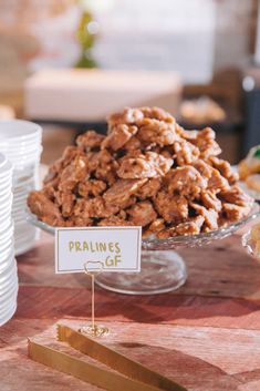 a table topped with lots of food next to stacks of plates and bowls on top of a wooden table