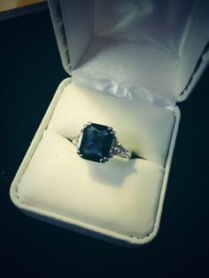 an engagement ring sitting in a white box