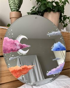 a mirror with clouds and stars painted on it