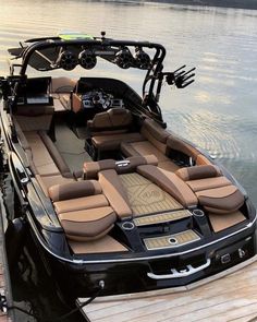 a boat is docked on the water with its seats folded down and steering wheel out