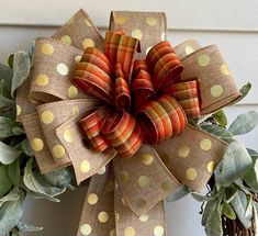 a close up of a wreath on a door with polka dot fabric and green leaves