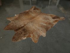 a brown and white cowhide rug on the floor