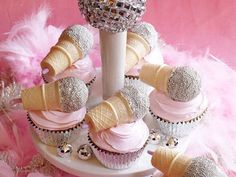 cupcakes and ice cream cones are arranged in a cone with pink icing