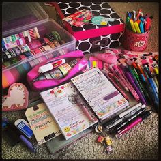 many school supplies are on the floor with pens and pencils in their containers next to each other