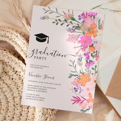 a graduation party card with flowers on it next to a straw bag and some other items