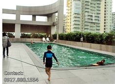 people are in the swimming pool near tall buildings