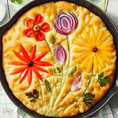 a pie decorated with flowers and herbs in a pan