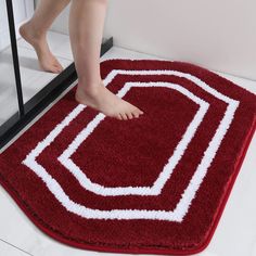 a person standing on a red rug with white lines in the middle and feet sticking out