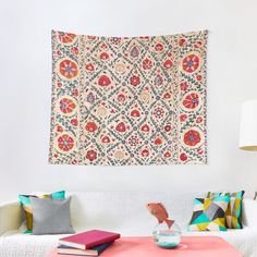 a living room with a white couch and colorful pillows on the wall next to it