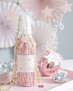 a bottle of champagne sitting on top of a pink tray next to some other decorations