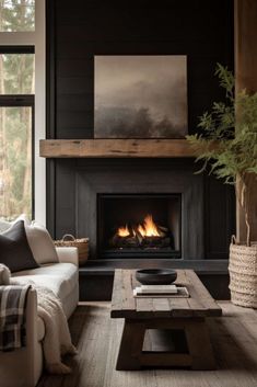 a living room with a couch, coffee table and fire place in front of a window