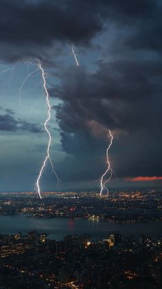 lightning strikes over the city at night time