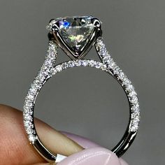 someone is holding an engagement ring with a diamond in it's center and side stones on the band