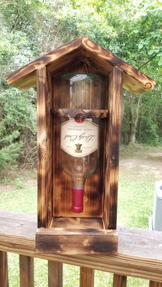 a wooden birdhouse with a wine bottle in it