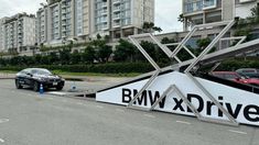 a bmw car is parked in front of a large advertisement on the side of a road