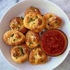 a white bowl filled with mini pizzas and sauce