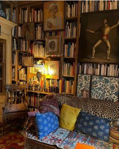 a living room filled with lots of furniture and bookshelves covered in pictures on the walls