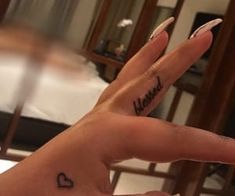 a woman's hand with the word heard written on it and a heart tattoo