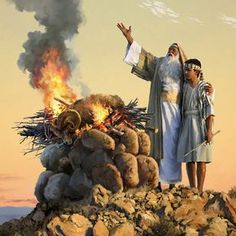 two men standing next to each other on top of a pile of rocks and fire