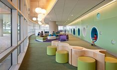 the interior of an office building with green carpet and white walls, large windows, and circular seating areas