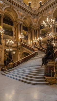 an ornate staircase with chandeliers and statues