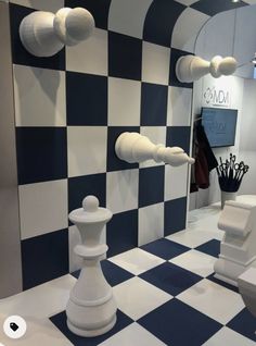 a room with checkered walls and white furniture on the floor in front of it