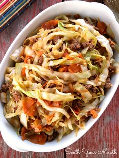 a white bowl filled with coleslaw on top of a wooden table