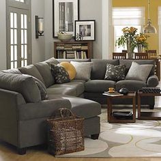 a living room filled with lots of furniture and decor on top of a hard wood floor