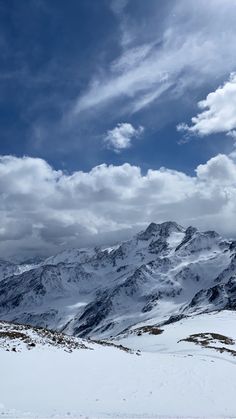 the mountains are covered in snow and clouds