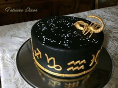 a black and gold decorated cake on top of a table