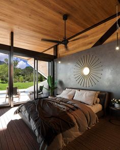 a large bed sitting in a bedroom next to a sliding glass door on top of a wooden floor