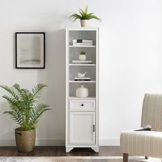 a grey bookcase next to a chair and potted plant