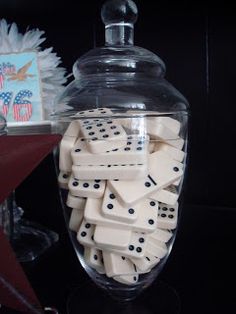 a glass jar filled with dominos on top of a table