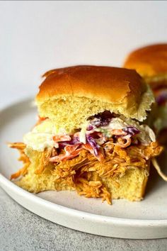 two pulled pork sandwiches on a white plate