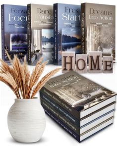 a white vase filled with books sitting on top of a table next to a stack of books