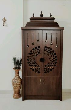 a wooden cabinet sitting next to a vase