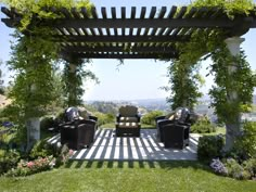 an outdoor seating area with chairs and greenery on the roof, in front of a beautiful view